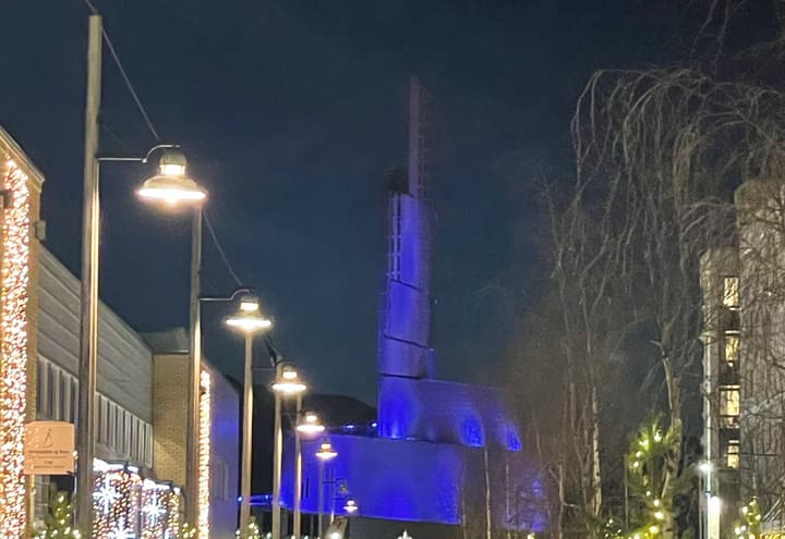 La cathédrale des Aurores boréales d’Alta éclairée en bleu par une soirée d’hiver enneigée