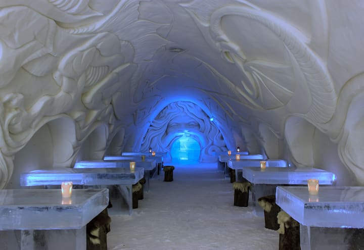 Eistische und geschnitzte Schneewände im SnowCastle-Restaurant in Kemi