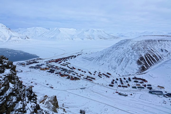 Colourful buildings in snow-covered Longyearbyen beneath Svalbard mountains, photographed in winter