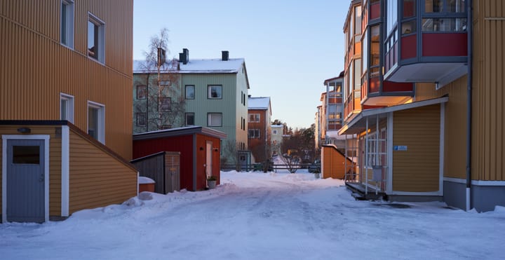 Schnee zwischen bunten Wohngebäuden im Stadtteil Varvet in Luleå an einem Januartag 2019