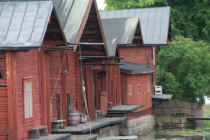 Historic red wooden warehouses and waterside platforms beside the river in the old town of Porvoo, Finland