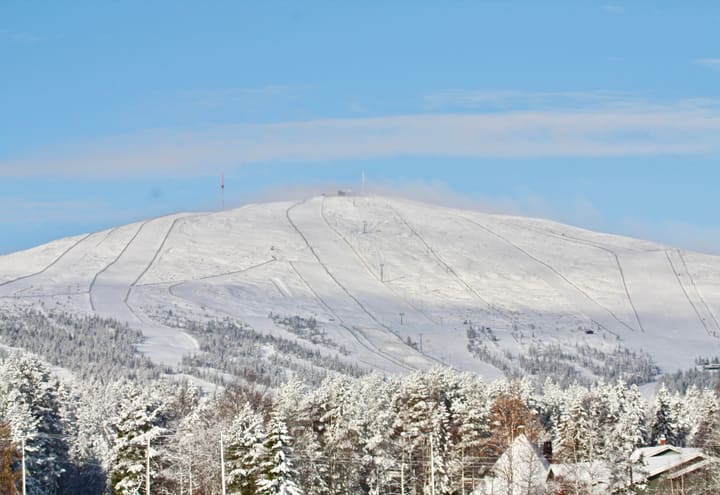 Verschneites Ylläs-Fjell mit seinen Skipisten, gesehen vom Eis des Ylläsjärvi-Sees